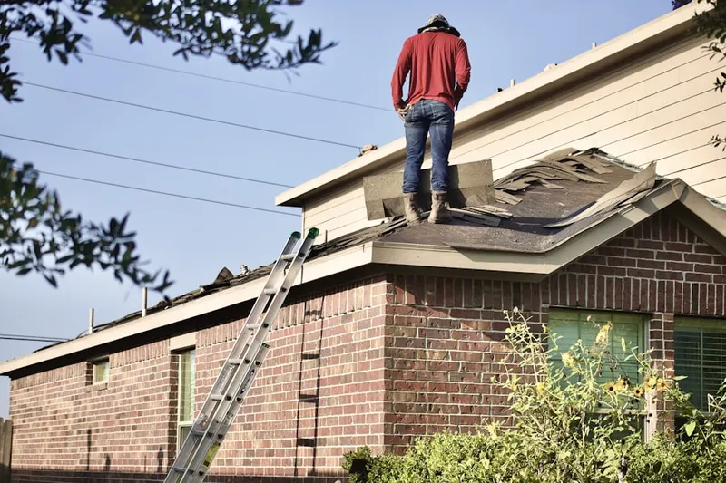 Professional roofer working on a residential roof in Melrose Manors